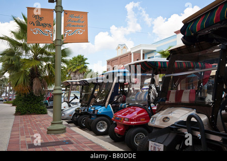 Des voiturettes de golf stationnée le long de la rue principale dans les villages de la communauté de retraite dans le centre de la Floride, USA Banque D'Images