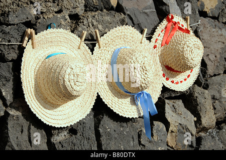 Les chapeaux de paille à la main dans les îles Canaries liée sur une ligne et en vente comme souvenirs pour les touristes. Banque D'Images