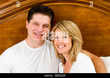 Couple Lying in Bed smiling togetherness Banque D'Images