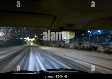 voiture roulant sur une route enneigée vide la nuit à l'intérieur le royaume-uni Banque D'Images