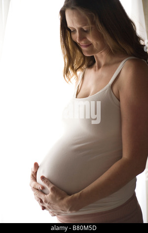 Femme dans la holding pregnant belly Banque D'Images