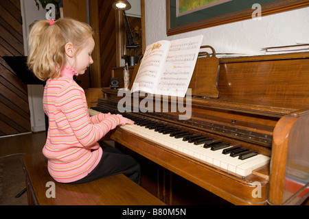 Fillette de six ans pratiquant le piano à la maison Banque D'Images