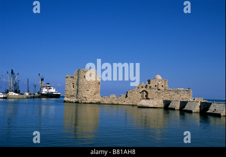 Les ruines de la mer château des Croisés à Sidon, au Liban, fournir un contraste historique contre la ville moderne de l'installation portuaire. Banque D'Images