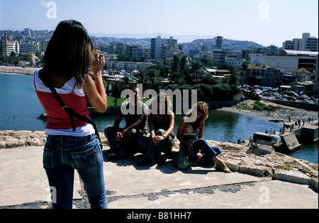 Une jeune femme libanaise prend une photo de groupe de ses amis lors d'une visite au château de la mer croisée à Sidon, au Liban Banque D'Images