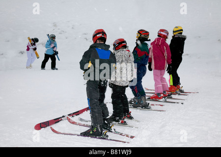 Children boys & girl learning to ski on the snow slopes at Glenshee Skiing Resort Scotland's premier extensive snowsports area, Aberdeenshire Scotland Banque D'Images
