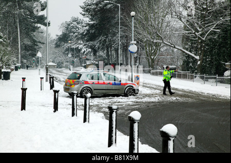 Offricer la police en service le détournement du trafic de Beckenham Hill Road, Lewisham après qu'il avait été fermé en raison de la glace et de la neige. Banque D'Images