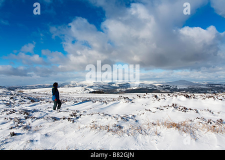 Woman looking at view vers les Montagnes Noires en hiver Pays de Galles UK Banque D'Images