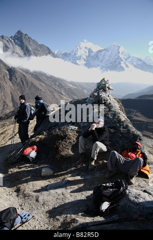 Les randonneurs prendre du repos par un cairn rock profitez de la vue de la vallée de Gokyo Népal Banque D'Images