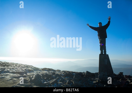 Un marcheur se dresse au sommet de l'Trig Point 719 mètres à Pen Alt Mawr dans les Montagnes Noires Powys Pays de Galles Royaume Uni Europe Banque D'Images