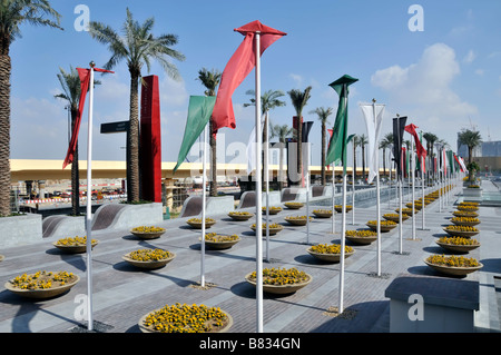 Jardinières et drapeaux dans l'aménagement paysager adjacent à Dubaï Mall Approach Roads ligne de métro au-delà de Dubai United Émirats arabes Unis Banque D'Images