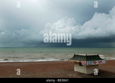 Un poisson et les puces buvette sur la plage de Brighton sous un ciel de mer orageuse Banque D'Images