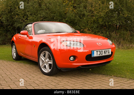 Un voyant rouge Mazda MX5 sports voiture garée sur une route en dehors d'une chambre Banque D'Images