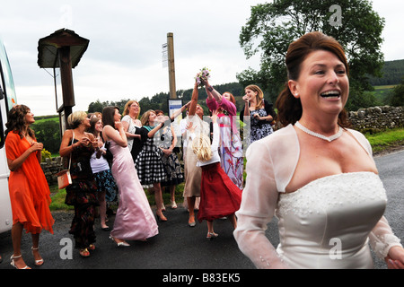 La mariée jette son bouquet pour les invités au mariage le North Yorkshire Banque D'Images