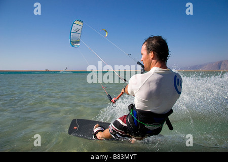 Un kitesurfeur traverse le lagon turquoise de l'eau plate (Qura Bay) au sein de la langue de sable dans la station balnéaire de Dahab Sinai en Egypte Banque D'Images