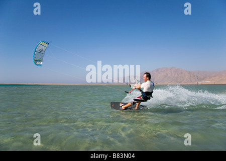 Un kitesurfeur traverse le lagon turquoise de l'eau plate (Qura Bay) au sein de la langue de sable dans la station balnéaire de Dahab Sinai en Egypte Banque D'Images