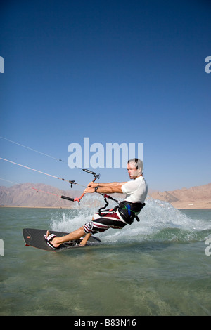 Un kitesurfeur traverse le lagon turquoise de l'eau plate (Qura Bay) au sein de la langue de sable dans la station balnéaire de Dahab Sinai en Egypte Banque D'Images