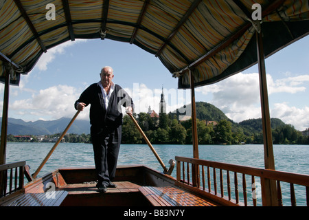 Un rameur propulse sa gondole sur le lac de Bled à l'île pour les touristes en Slovénie, Gorenjska Banque D'Images