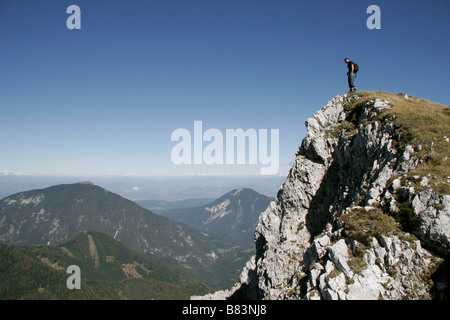 Un randonneur se dresse sur le bord d'une falaise sur le Veliki vrh randonnée dans les montagnes Karavanke, Slovénie, Gorenjska Banque D'Images