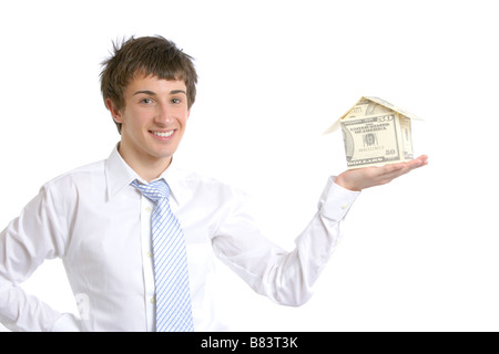 Business man holding une maison faite de l'argent dans le studio Banque D'Images