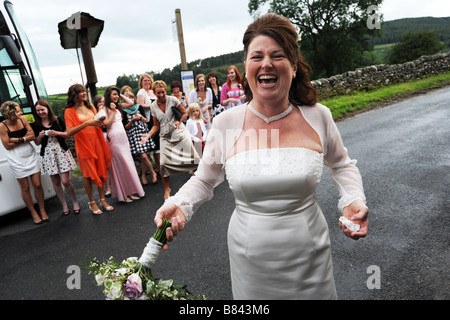 La mariée jette son bouquet pour les invités au mariage le North Yorkshire Banque D'Images