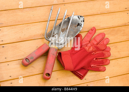 Utilisation d'outils de jardin à manche rouge et de nouveaux gants Banque D'Images