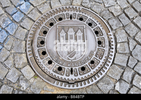 Couvercle avec armoiries sur un cobbledstoned street Prague Banque D'Images
