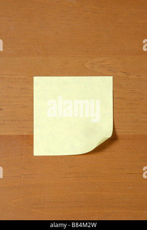 Un post it sur un bureau en bois à un bureau Banque D'Images