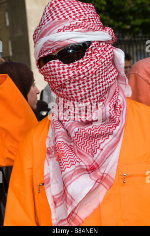 Dans l'homme foulard arabe, lunettes noires et orange répondre à Downing Street pour protester contre la libération de Binyam Mohamed, détenu à Guantanamo Bay Banque D'Images