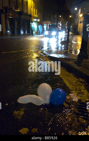 Party baloons sont abandonnés dans un caniveau à l'état humide et venteux nuit à Carmarthenshire Carmarthen Wales United Kingdom Europe Banque D'Images