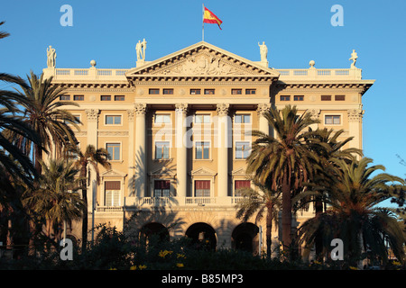 Gobierno Militar bâtiment à la partie inférieure de Las Ramblas, Barcelone, Espagne. Drapeau espagnol avant de ciel bleu. Banque D'Images