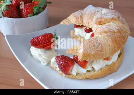 Croissant frais farci de crème et des fraises fraîches Banque D'Images