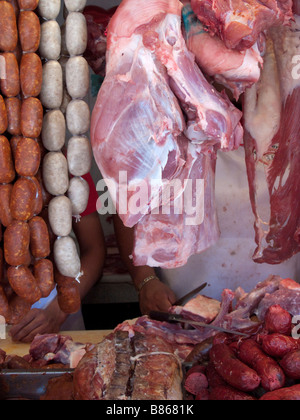 Cordes de saucisses et de dalles de la viande crue pendre pendaison à l'étal d'un boucher dans le Mercado Juarez, la Ville d'Oaxaca, Oaxaca, Mexique Banque D'Images