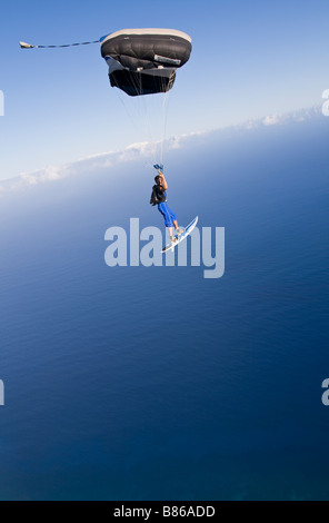 Parachutiste sous l'auvent est volant le long de la ligne de coût à partir d'Hawaï se prépare à faire un atterrissage avec une plage de surf. Banque D'Images
