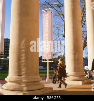 Femme marche et de colonnes à l'extérieur de l'entrée à la Saatchi Art Gallery à Chelsea Londres Angleterre Royaume-uni KATHY DEWITT Banque D'Images