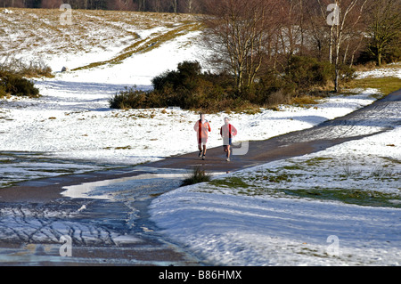 Deux coureurs à Sutton Park en hiver, West Midlands, England, UK Banque D'Images