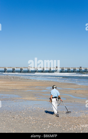 Homme âgé la plage avec un détecteur de métal en face de la jetée, Jacksonville Beach, Florida, USA Banque D'Images