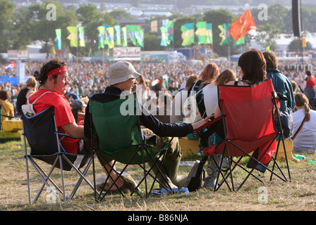 Un groupe d'amis, profiter du soleil en face de la foule au festival de Glastonbury dans Pilton, Somerset au Royaume-Uni. Banque D'Images