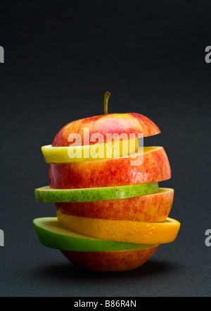 Pile de tranches de fruits - citron, poire, orange et les tranches de pomme Granny Smith collée dans un tranchage braeburn apple Banque D'Images