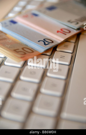 Une pile / pile de nouveaux billets de banque en monnaie ( ) sur le clavier d'un ordinateur. Banque D'Images