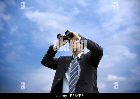 Businessman using binoculars Vue de dessous Banque D'Images