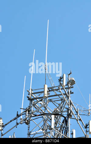 Partie supérieure d'une tour de téléphonie cellulaire contre le ciel bleu clair montrant antennes pour transmettre des signaux de téléphone mobile cellulaire USA Banque D'Images