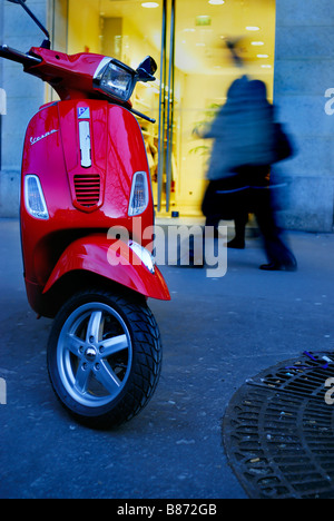 Paris France, des magasins de luxe, de scooters Vespa rouge garée sur un trottoir à l'extérieur de magasin de vêtements à la tombée de la 'Rue Royal Banque D'Images