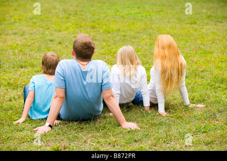 Family sitting on grass vue arrière Banque D'Images