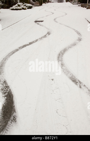 Marques de dérapage dans la neige, d'une voiture sur une route escarpée à Ambleside UK Banque D'Images