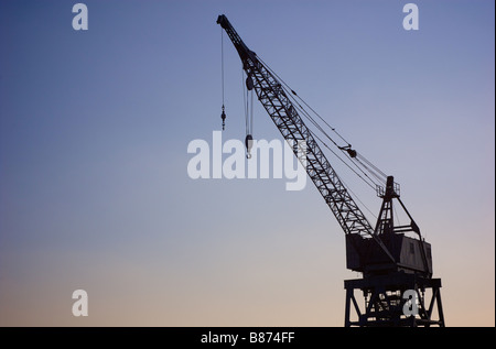 Profil simple de grue de chargement port au crépuscule Banque D'Images