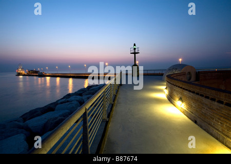 Dock au crépuscule avec phare et bateau Banque D'Images