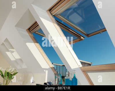 De grandes fenêtres Velux ouvert avec ciel bleu et carafes en verre bleu Banque D'Images