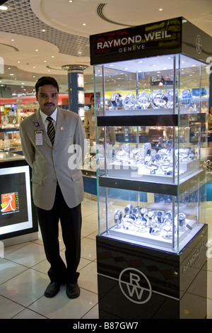 Shop assistant et un étalage de montres à vendre dans une salle de départ d'une boutique. L'aéroport international de Bahreïn. Banque D'Images