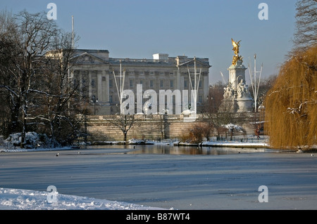 Vue depuis St James Park sur le lac et le palais de Buckingham et le Queen Victoria Memorial en hiver la neige. Banque D'Images