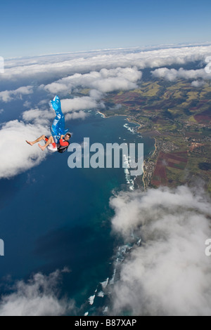 Parachutiste saute sur Hawaï avec un air gonflable jouet dans ses bras. Le plongeur a beaucoup de temps à jouer avec le jouet. Banque D'Images